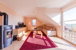 a living room with a couch and a fireplace at Storchenflug - Dachgeschosswohnung mit Kamin & Balkon am Fleesensee in Göhren-Lebbin
