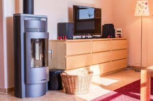 a living room with a coffee machine and a tv at Storchenflug - Dachgeschosswohnung mit Kamin & Balkon am Fleesensee in Göhren-Lebbin +12 photos
