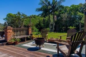 two chairs and a bench on a wooden deck at Vieja Hacienda in Praia do Rosa