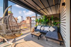 a balcony with a couch and a swing at Terrazza con Jacuzzi e Vista Iconica sul Duomo in Milan
