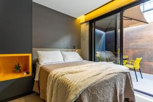 a bedroom with a bed and a large window at Soul Housing & Shop · Studio com varanda. Noroeste. Soul Housing & Shop in Brasilia