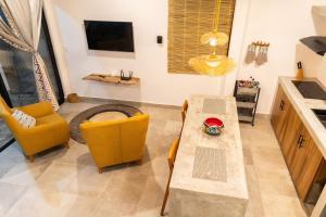 a living room with a table and chairs and a tv at Casa Teotl Puerto Escondido in Brisas de Zicatela