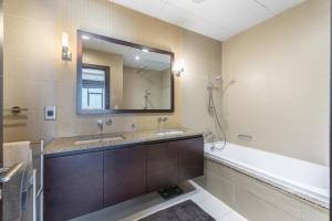 a bathroom with two sinks and a tub and a mirror at Emerald at Tiara Beach Residences with Atlantis views in Dubai