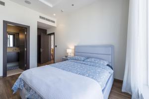 a bedroom with a large bed with a blue blanket at Emerald at Tiara Beach Residences with Atlantis views in Dubai
