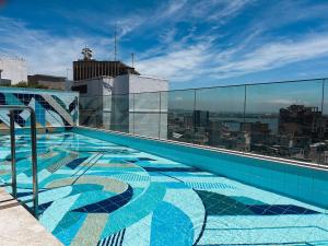 a swimming pool on the roof of a building at Estúdio sofisticado no centro do Rio com vaga de garagem in Rio de Janeiro