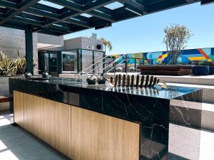an outdoor kitchen with a black counter top at Estúdio sofisticado no centro do Rio com vaga de garagem in Rio de Janeiro
