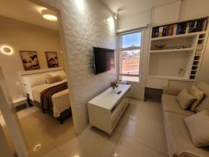 a bedroom with a bed and a couch and a tv at Toscana Asa norte · Kit aconchegante na Asa norte in Brasilia