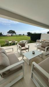 un patio con muebles blancos y vistas a un campo en Appartement Jardin et Vue Golf, en San Roque 23 fotos más