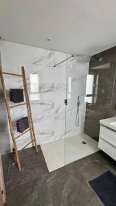 Un baño con ducha con puerta de cristal. en Appartement Jardin et Vue Golf, en San Roque