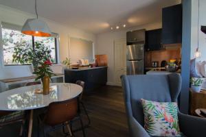 a kitchen and living room with a table and chairs at Harmonica - unique modern chic apartment in Katoomba