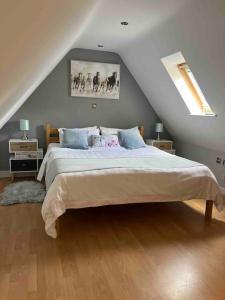 a bedroom with a large bed in a attic at Ty Gardd - Luxury lodge with covered hot tub in Usk