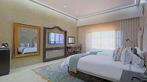 a bedroom with a large bed and a mirror at Qurtuba Resort and Events in Sandown +136 photos