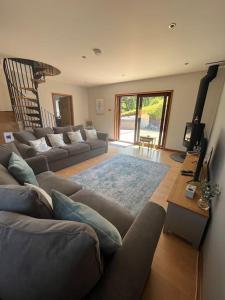 a living room with a couch and a table at Ty Gardd - Luxury lodge with covered hot tub in Usk