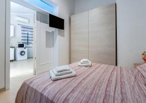 a bedroom with a large bed with towels on it at Casa Fatmin in Tirrenia