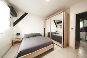 a bedroom with a bed and a large mirror at Bretzel Home in Colmar