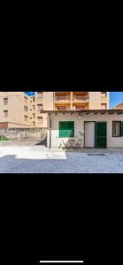a building with green doors and a building at Casa Fatmin in Tirrenia