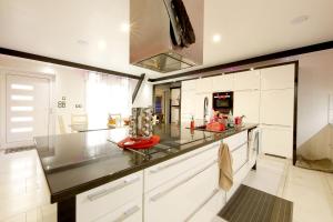 a kitchen with white cabinets and a black counter top at Bretzel Home in Colmar