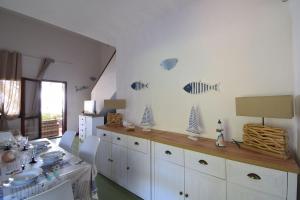 a dining room with a table and white cabinets at Villa Sul Porto in Porto Ottiolu