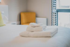 a pile of towels sitting on top of a bed at Polzeath Beach House in Polzeath