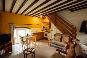 a living room with a table and a kitchen at Barn Cottage - Family-Friendly Cottage with Heated Indoor Pool in Haverfordwest