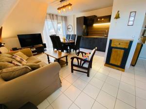 a living room with a couch and a table at Escale à Balbec- Proche plage et Centre ville Cabourg in Cabourg