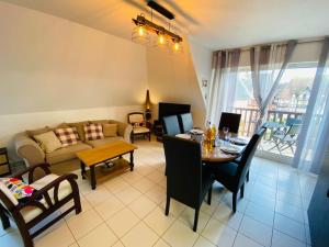 a living room with a couch and a table with chairs at Escale à Balbec- Proche plage et Centre ville Cabourg in Cabourg