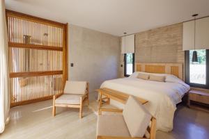 a bedroom with a bed and a table and a chair at Lodge Tunuyan, Destino Uconia in Vista Flores