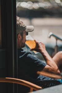 a man sitting in a chair drinking a drink at Polzeath Beach House in Polzeath