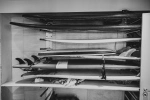 a bunch of surfboards are stacked on a shelf at Polzeath Beach House in Polzeath