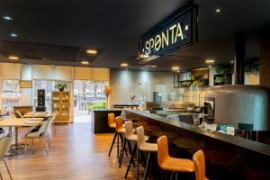 a restaurant with a bar with chairs and tables at ibis Piracicaba in Piracicaba