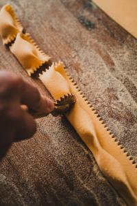 a person is stitching a piece of fabric on a table at Polzeath Beach House in Polzeath