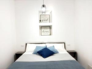 a bedroom with a bed with two pictures on the wall at San Giovanni Apartment in Catanzaro