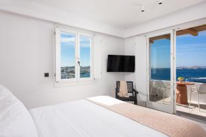 a bedroom with a bed and a view of the ocean at Porto Mykonos in Mikonos
