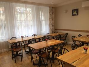 Un comedor con mesas y sillas de madera. en St Simeon, en Londres 37 fotos más