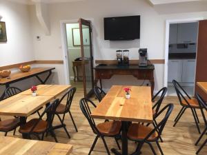 Habitación con mesas, sillas y TV. en St Simeon, en Londres