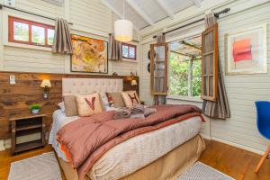 a bedroom with a bed and a desk and windows at Vieja Hacienda in Praia do Rosa +102 photos