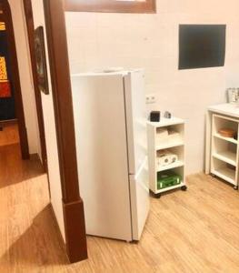 a white refrigerator in a room with a shelf at Private Room 101 in Guest House da Fonte in Figueira da Foz