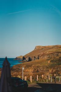 a car parked on a road next to the ocean at Polzeath Beach House in Polzeath