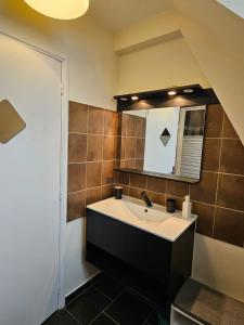 a bathroom with a sink and a mirror at Le Petit Nice Maison semi-troglodyte de charme. in Vouvray +32 photos