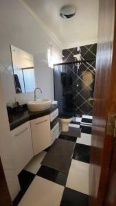 a bathroom with a sink and a black and white checkered floor at Ap da Auri in Petrolina