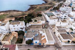 an aerial view of white buildings near the ocean at Petracca home in Torre San Giovanni Ugento