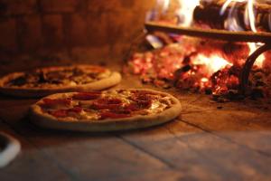 two pizzas are sitting in front of a fire at Primaluna Beach Hostel in Palomino