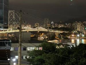 a bridge over a river with a city at night at Cantinho do Mané in Florianópolis +3 photos