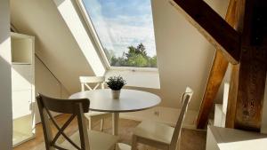 a small table and chairs in a room with a window at Work & Stay- vollausgestattet mit Garten & Parkplatz in Blankenfelde