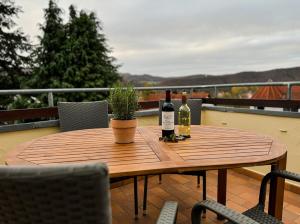 a wooden table with two bottles of wine and a plant at Villa Herzog in Bad Sooden-Allendorf