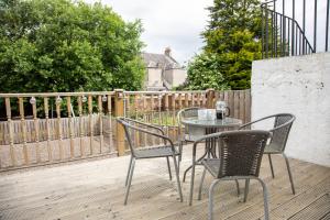 a patio with a table and chairs on a deck at Glebe Street Apartment in Fife