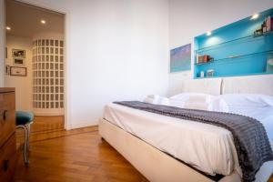 a bedroom with a bed with white sheets and a blue wall at Vatican Museum apartment by Varental in Rome