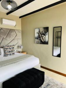 a bedroom with a large bed and a mirror at Elephant Boutique Lodge in Tswinga