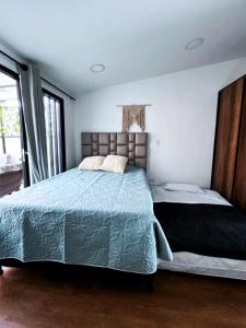 une chambre avec un lit avec une couette bleue dans l'établissement Posada Botero, à San Andrés