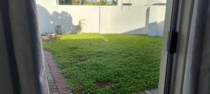 vista su un cortile da una porta scorrevole in vetro di Seaview Self catering cottage a Sea View